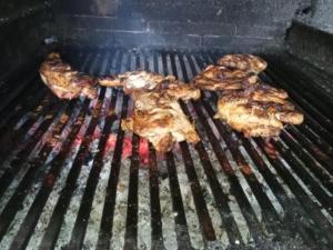 three pieces of meat cooking on a grill at LEBADA de VARA in Mahmudia