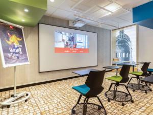 a conference room with tables and chairs and a screen at Ibis Paris Tour Eiffel Cambronne 15ème in Paris