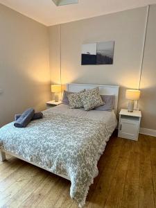a bedroom with a bed with two night stands and two lamps at Teach Duff in Clonmany +4 photos