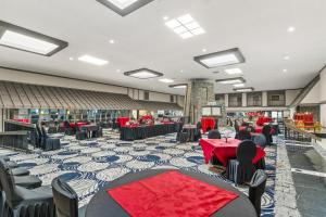 a banquet hall with tables and chairs and red table cloth at Red Lion Hotel & Conference Center Cheyenne in Cheyenne +40 photos