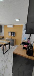 a living room with a table and a kitchen at Тера Лакшъри Суит in Asenovgrad