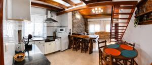 a kitchen with a table and chairs and a spiral staircase at Apartamento Cholo in Brañosera