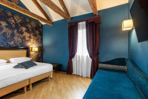a bedroom with blue walls and a bed and a window at Hotel Paganelli in Venice