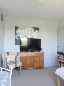 a living room with a flat screen tv on a wooden cabinet at Sawston Village in Sawston