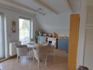 a kitchen with a table and chairs in a room at Ruhige, moderne Maisonette Ferienwohnung Rügensonne mit großem Balkon - umgeben vom Wasser in Breege +11 photos