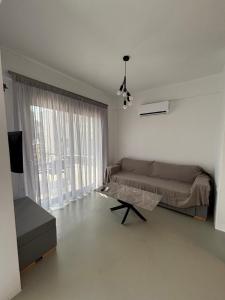 a bedroom with a bed and a large window at Almira Suites by the sea 3 in Áyios Dhimítrios