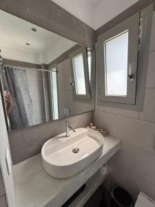a bathroom with a sink and a mirror at Almira Suites by the sea 3 in Áyios Dhimítrios +26 photos