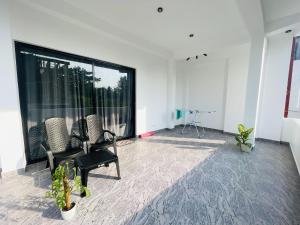 an empty room with two chairs and a large window at The Ocean Deck Apartments in Moragalla +12 photos
