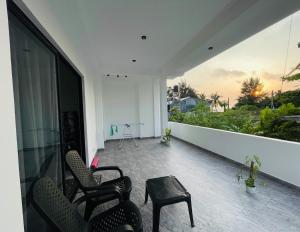 a room with chairs and a table on a balcony at The Ocean Deck Apartments in Moragalla