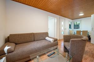 a living room with a couch and two chairs at Ferienhaus am Strand 88 - Bade- & Saunawelt täglich inklusive in Baabe +15 photos