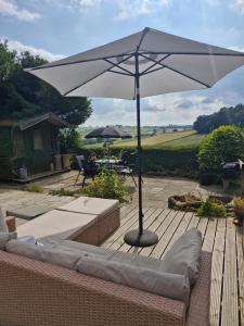 a large white umbrella sitting on a wooden deck at Foxhollies in Ashbourne