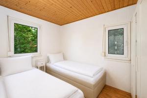 two beds in a room with two windows at Ferienhaus am Strand 88 - Bade- & Saunawelt täglich inklusive in Baabe