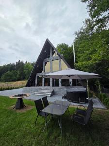 a picnic table with an umbrella in front of a building at The Robian Chalet in Suceviţa