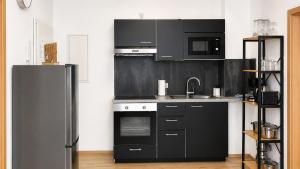 a kitchen with black appliances and a black refrigerator at Comfortable new Apartment in #Koblenz# direkt am Rhein in Koblenz