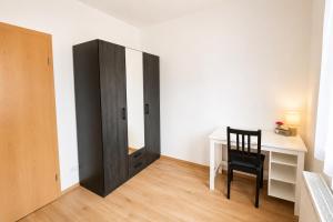 a room with a desk and a chair and a closet at Comfortable new Apartment in #Koblenz# direkt am Rhein in Koblenz