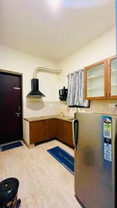 a kitchen with a stainless steel refrigerator and wooden cabinets at Maxi villa maamalla in Mahabalipuram