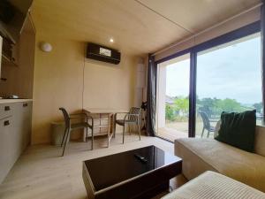 a living room with a couch and a table with chairs at Filao - Clim Piscine in Auch