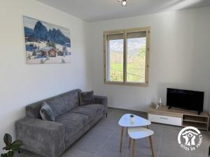 a living room with a couch and a tv at Le canigou in Fuilla