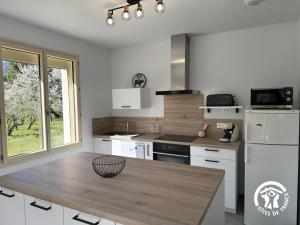 a kitchen with white appliances and a wooden table at Le canigou in Fuilla +12 photos