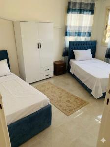 a bedroom with two beds and a cabinet in it at dalina resort in El Alamein
