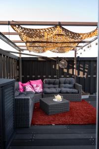 a patio with a couch and a table on a red rug at Slapen bij Ticho in Yerseke