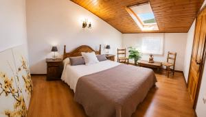 a bedroom with a bed and a table and chairs at Apartamento Cholo in Brañosera