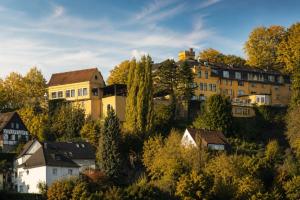 a group of houses on a hill with trees at Burghotel Volmarstein in Wetter