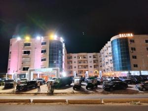 a parking lot in front of two buildings at night at dalina resort in El Alamein