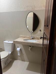 a bathroom with a sink and a mirror and a toilet at Aconchego da serra no centro de Pacoti in Pacoti +8 photos