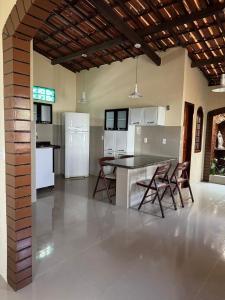 a kitchen with white appliances and a table and chairs at Aconchego da serra no centro de Pacoti in Pacoti