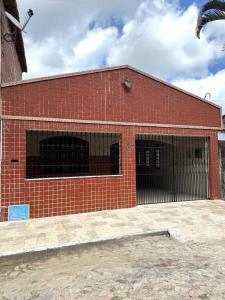 a red brick building with two garage doors at Aconchego da serra no centro de Pacoti in Pacoti