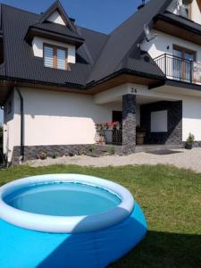 a house with a blue pool in front of a house at Wiyrchowianka in Gliczarów Górny