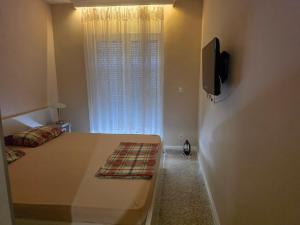 a bedroom with a bed and a tv and a window at Budva Centar in Budva
