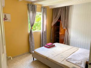 a bedroom with a bed and a window at Maison de charme avec vue sur mer à Bas Vent - Confort optimal in Bas Vent