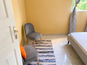 a room with two chairs and a rug at Maison de charme avec vue sur mer à Bas Vent - Confort optimal in Bas Vent