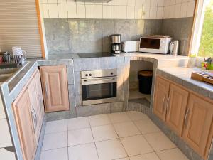 a kitchen with a stove and a microwave at Maison de charme avec vue sur mer à Bas Vent - Confort optimal in Bas Vent +4 photos