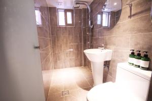 a bathroom with a sink and a toilet and a shower at 벨린 호텔 in Kŏje +2 photos
