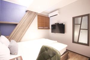 a bedroom with a bed and a window and a tv at 벨린 호텔 in Kŏje