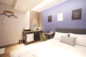 a bedroom with a bed and a desk with a computer at 벨린 호텔 in Kŏje