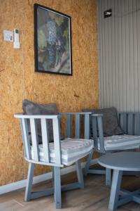 two chairs and a table and a picture on the wall at La Misión Tiny Houses in Ciudad Lujan de Cuyo