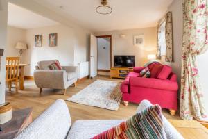 a living room with a pink couch and a tv at Acorn House in Briston
