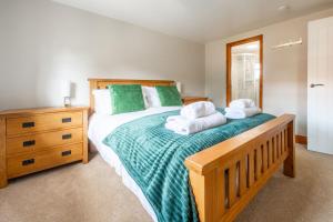 a bedroom with a large bed with towels on it at Acorn House in Briston