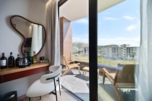 a room with a mirror and a balcony with a view at Hotel Potami in Himare