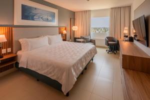 a hotel room with a large bed and a desk at Holiday Inn Acapulco La Isla by IHG in Acapulco