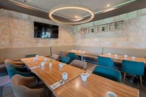 a restaurant with wooden tables and blue chairs at Holiday Inn Acapulco La Isla by IHG in Acapulco +89 photos