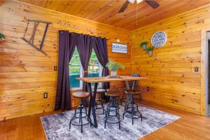 a dining room with a table and stools at The Old Homestead in Roulette