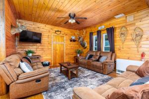 a living room with leather furniture and a ceiling fan at The Old Homestead in Roulette