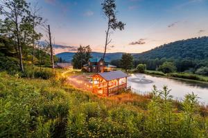 a house sits on the side of a river at The Old Homestead in Roulette