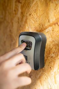 a person holding a remote control on a wall at La Misión Tiny Houses in Ciudad Lujan de Cuyo
