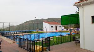 a large swimming pool with a green fence around it at Marchena de los Olivos in Peñolite